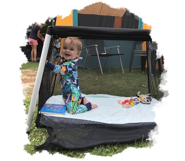 young toddler playing in travel cot at camping site with the easy zip down side mesh open - philandteds